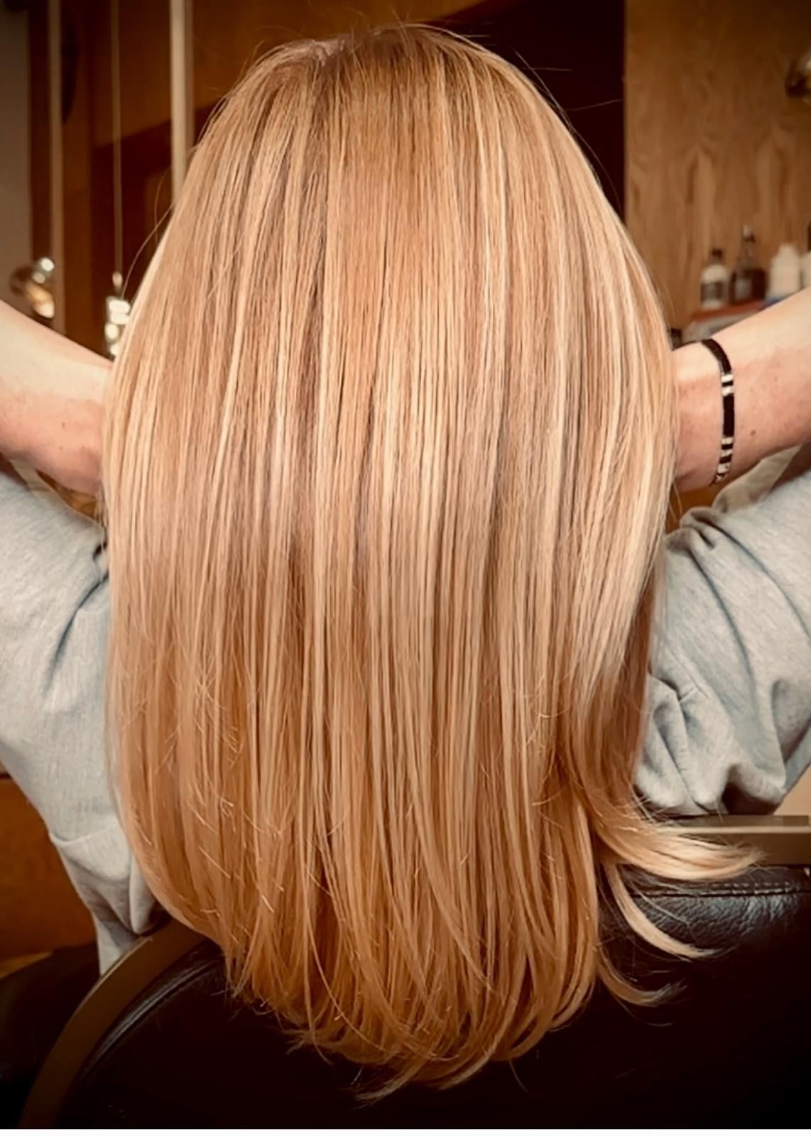 Longueurs blondes lissées et brillantes, vues de dos après un passage au salon