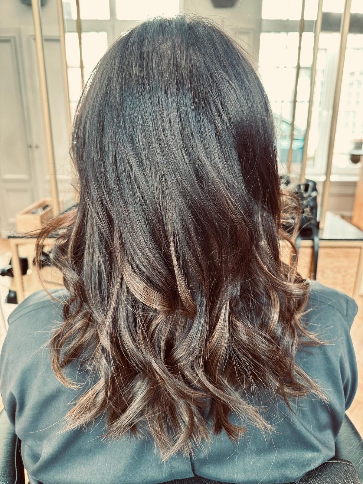 Cheveux bruns mi-longs ondulés aux pointes éclaircies, vus de dos au salon du Vieux-Lille