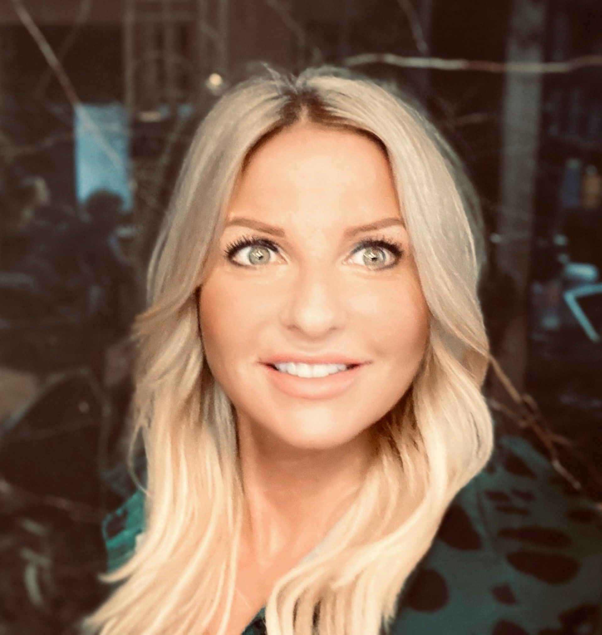 Portrait d'Eva, fondatrice et coloriste de la Maison de Coiffure Eva, cheveux blonds lumineux et ondulés